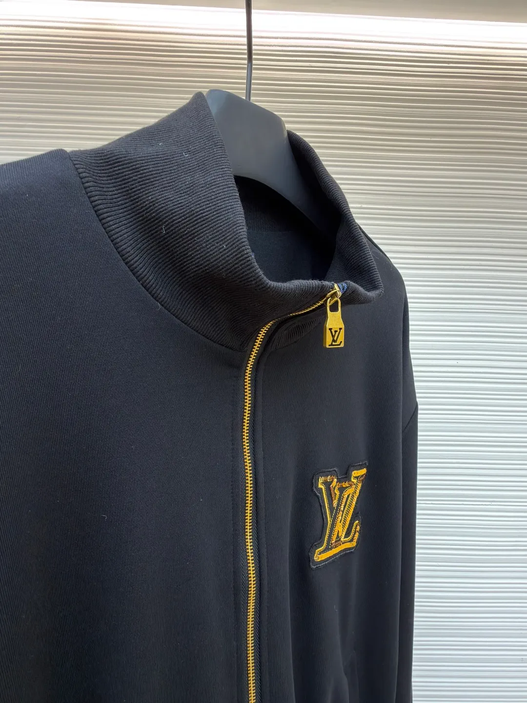 LOUIS VUITTON stand-up collar ribbed hem long-sleeved logo decorated jacket ●Original version: Purchased and developed at 25899 ●Item number: 1682404-B25 ●Fabric: cotton fabric ●Technology: knitted production ●Color: black ●Version: fitted version ●Weight: about 990 grams ●Size: S-M-L-XL ●Description: This Louis Vuitton stand-collar zipper jacket is made of high-thread-count cotton-elastic blended fabric, which has been treated with enzyme washing process. The fabric is soft to the touch and has good wrinkle resistance and elasticity. The body has a delicate matte texture. The LV logo on the chest uses a combination of gold thread embroidery and patchwork. The embroidery uses interlaced flat stitch and chain stitch techniques. The stitch density reaches 12 stitches per centimeter. The edges are overlocked and the pattern is three-dimensional and not easy to fall off. The jacket adopts a stand-up collar design, and the collar ribs are made of spandex blended material, which has been shaped to ensure that it will not loosen after long-term wear. The front is equipped with a custom brass zipper, and the zipper teeth are polished and gold-plated, making it smooth, wear-resistant and of high-quality texture. The side seam pockets are welted, and the seams are reinforced with double-needle sewing. The ribbed edges of the cuffs and hem are woven with high-elastic yarns of the same color. The shoulders are seamlessly spliced ​​with natural shoulder shapes. The overall craftsmanship combines the brand's classic elements with practical design, fully demonstrating the production level of high-end clothing. The overall wiring is straight and delicate, the fabric is comfortable and soft, and the color is consistent without color difference. It can be matched with the same style to create a fashionable look and control various occasions. Customized accessories, complete with three standards, same style for men and women!